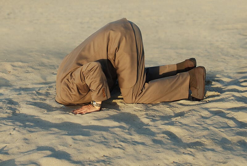 business man head in sand