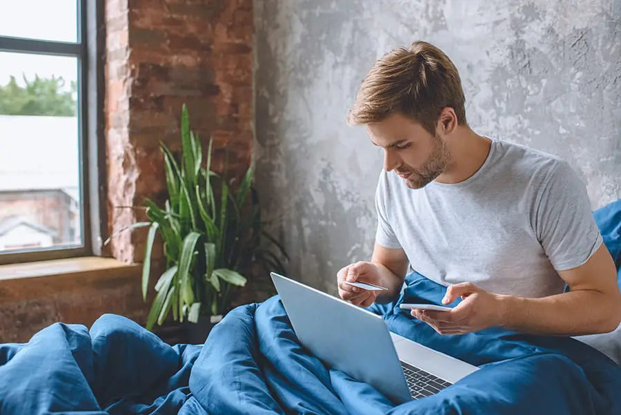 - guy in bed on laptop