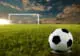 Close up on football on pitch with goal