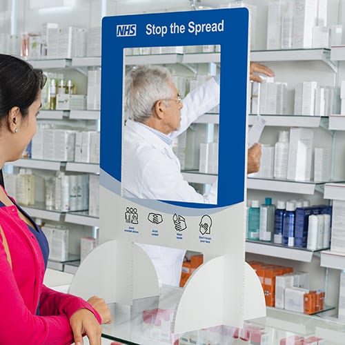 Young woman looking at chemist searching for medicine in shelves at pharmacy