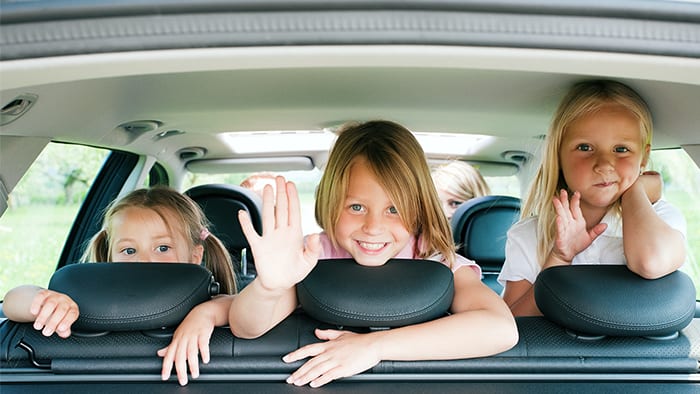 Kids laughing and waving in car