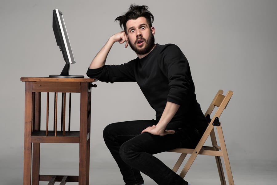 Man sitting at desk looking shocked