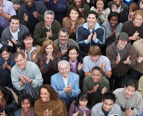 Group of people looking up and clapping