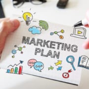 Mans hand drawing Marketing Plan concept on notebook