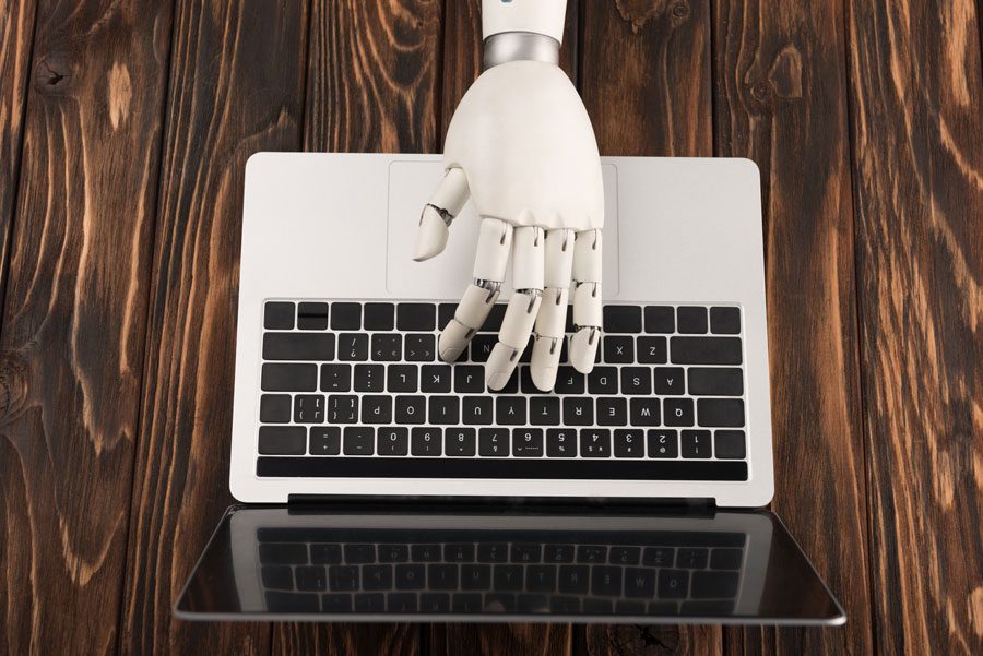 Robot hand on keyboard signalling our relationship with AI for search marketing SEO